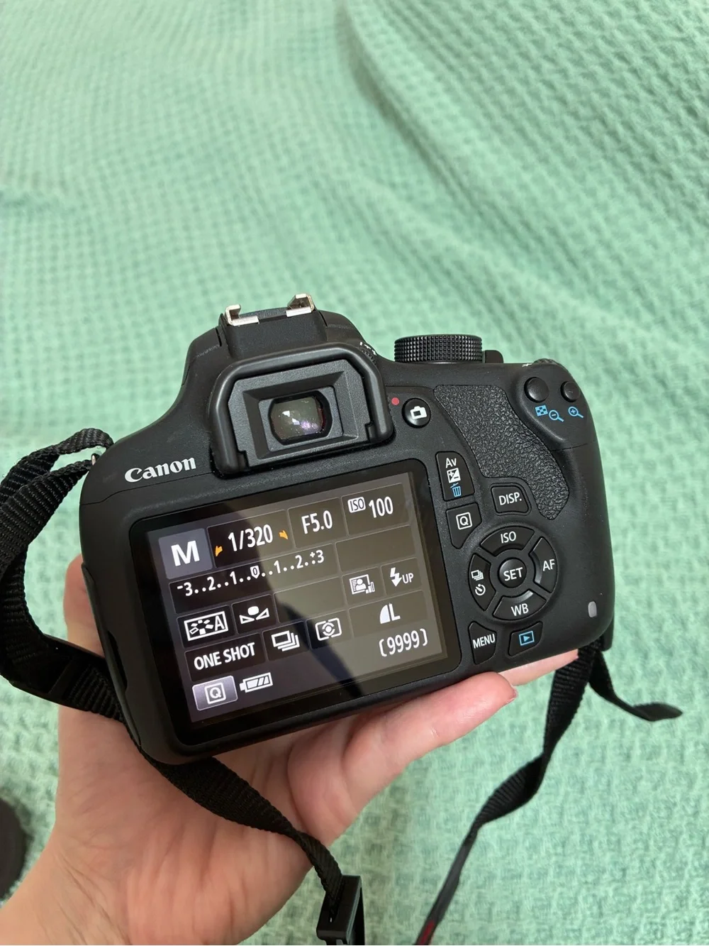 Canon DSLR Camera Body in Black with Red Strap Accents and kit lens.
